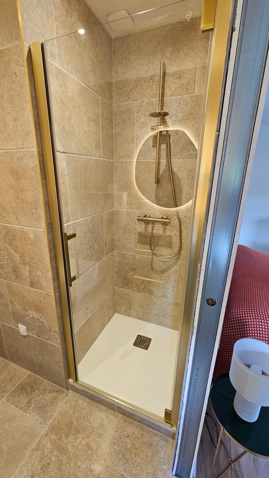 Douche avec robinetterie dorée et niche rétro-éclairée